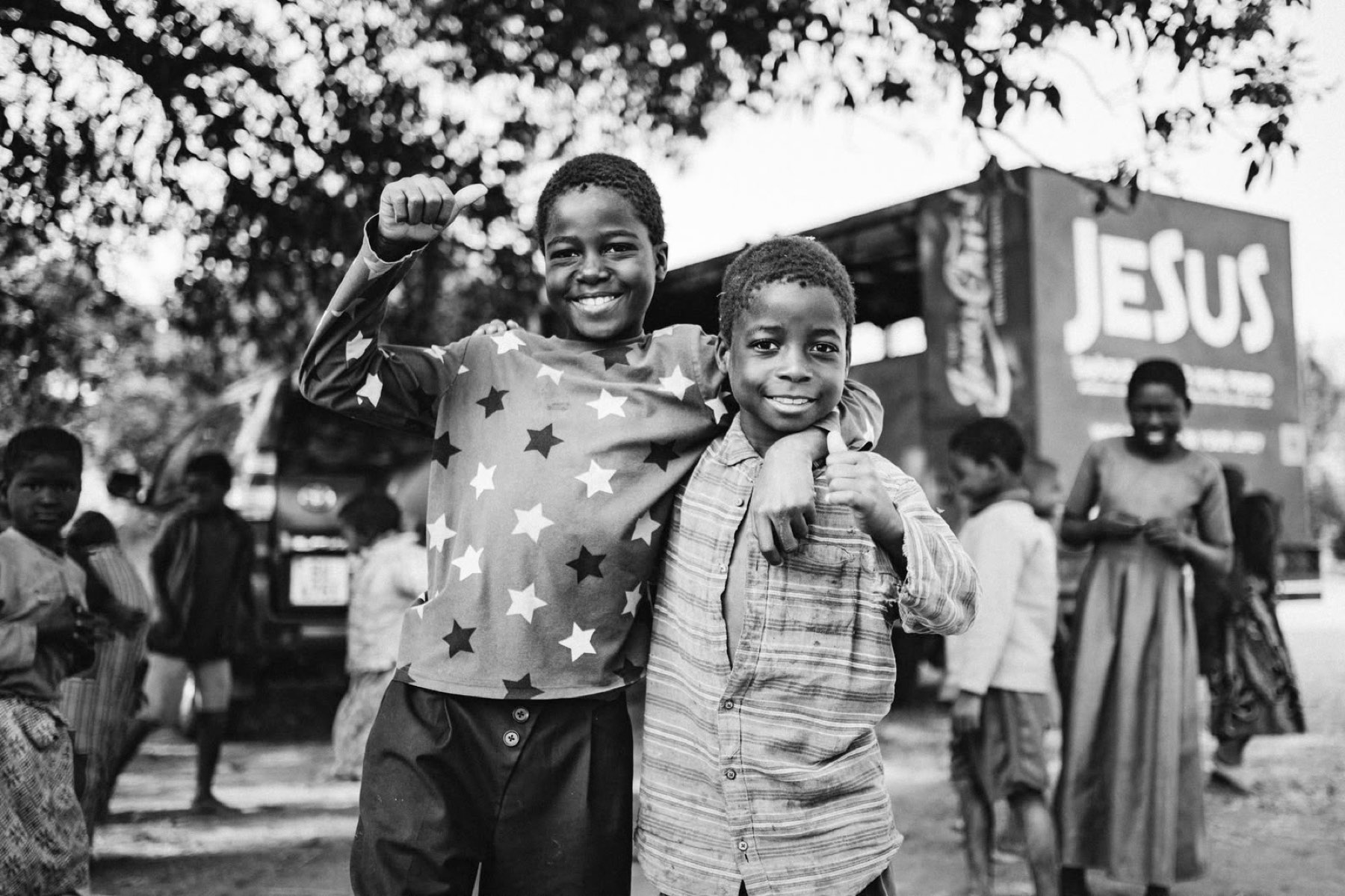 Two boys smiling in front of the Jesus truck