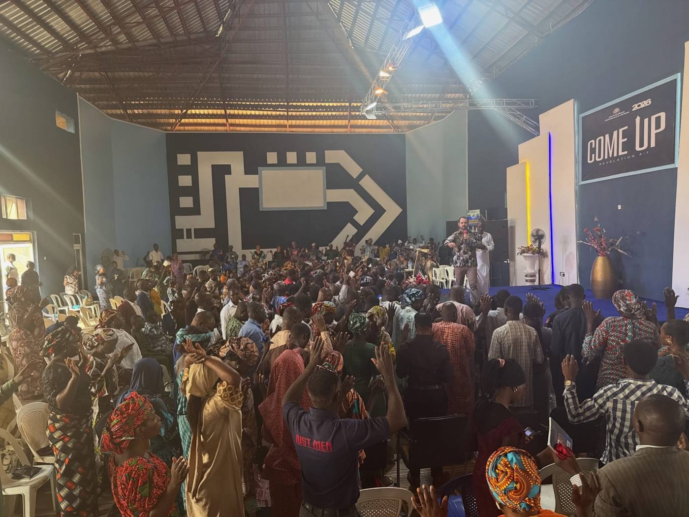 A full church hall in North Nigeria with hands raised in worship