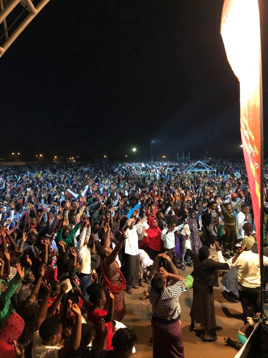 Hands raised in the crowd at a night crusade in Uganda