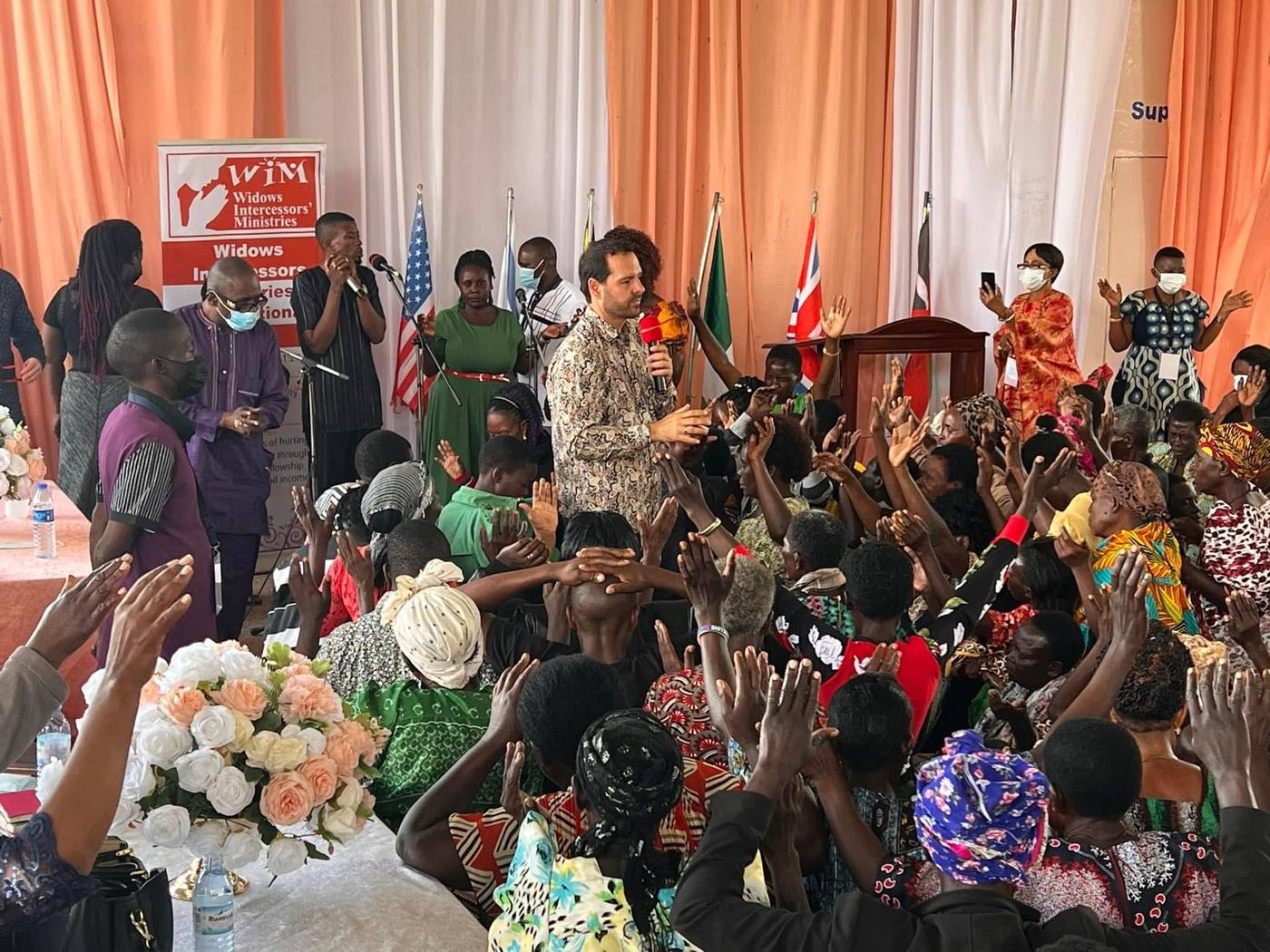 Praying with widows at a gathering in Uganda