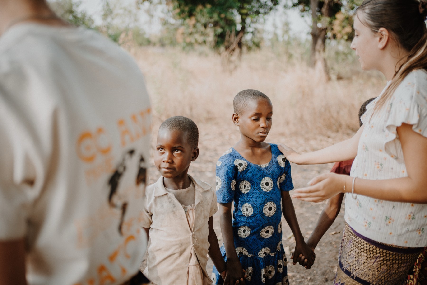 A team member walking hand in hand with village children