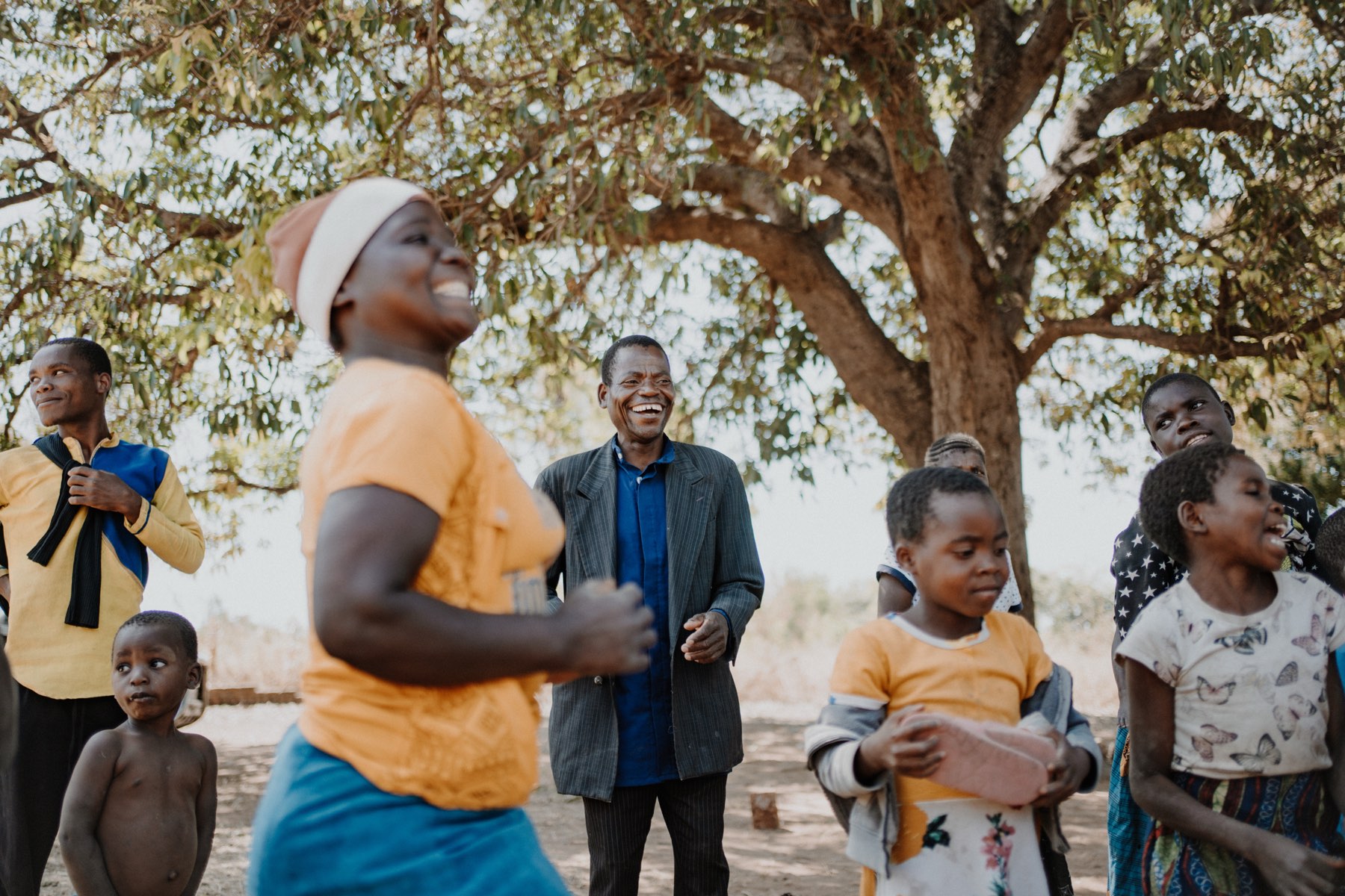 Villagers laughing together under a tree